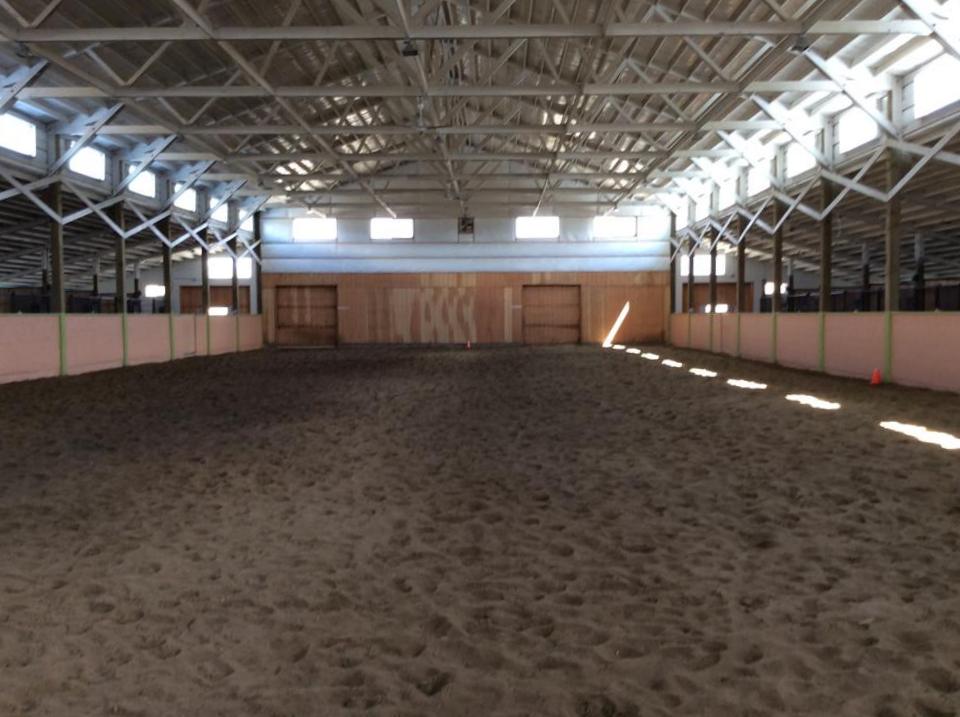 Indoor arena with stalls off of both sides. 12 foot concrete isle ways have tubing in them to heat in winter and cool in summer…with circulating water.
