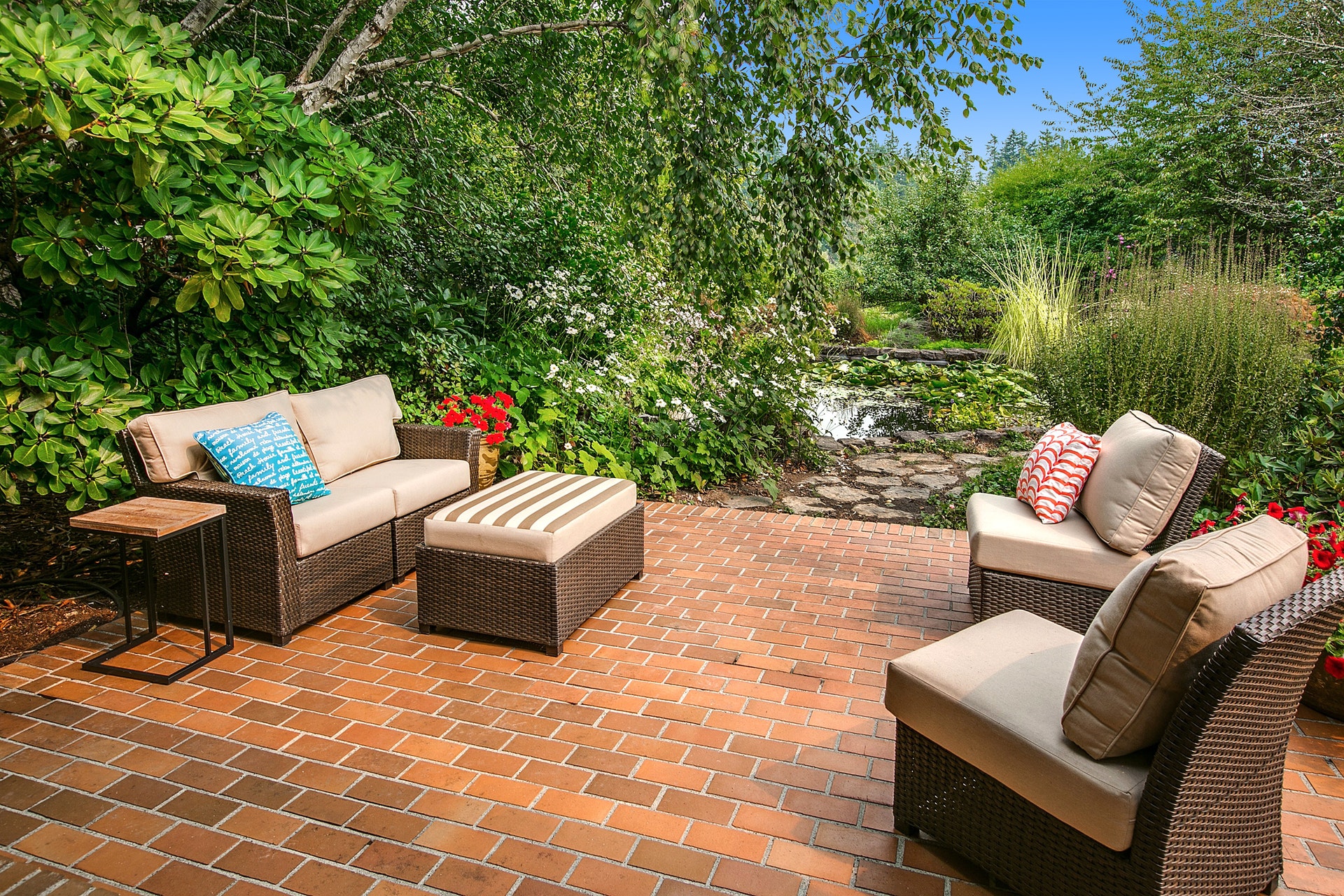 A restful brick patio and fish pond invites relaxation just outside the living/dining rooms